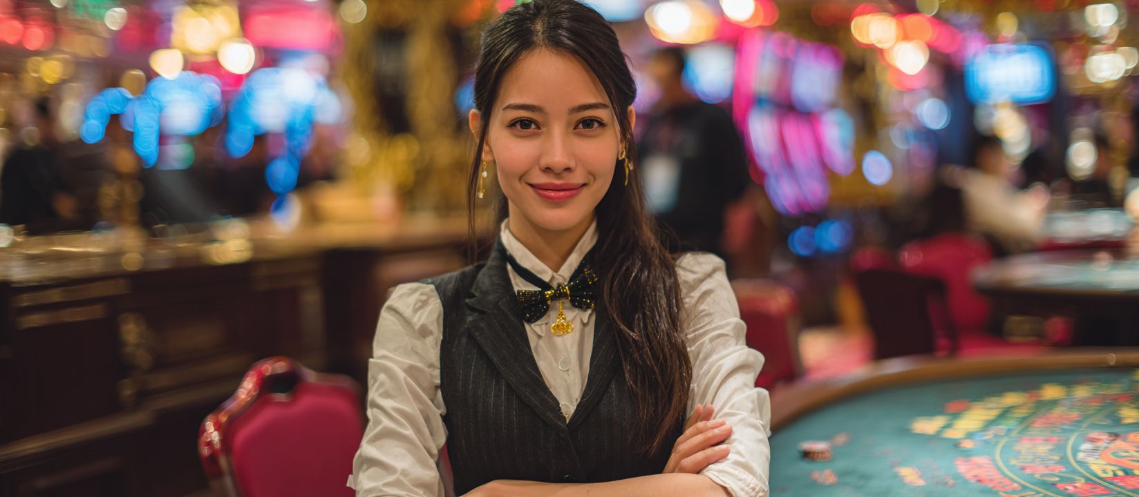 Friendly casino dealer standing behind a game table in a luxurious casino, ready to welcome players